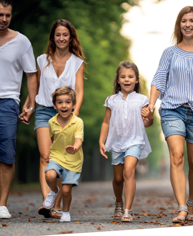 Familie geht gemeinsam einen Weg entlang