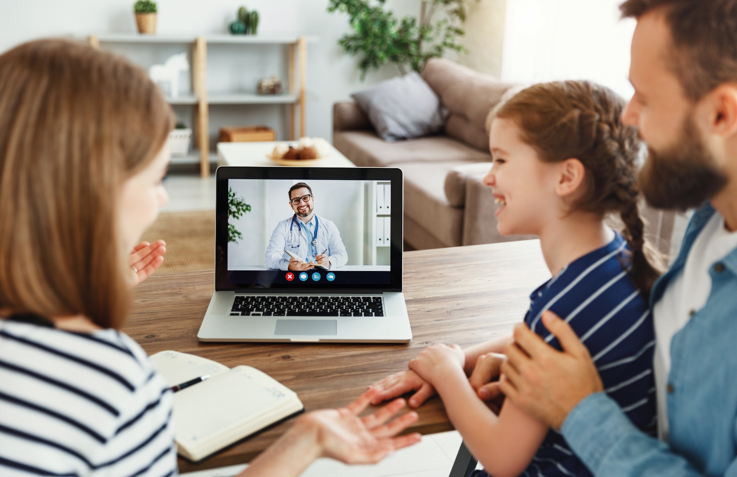 Eine Familie nutzt gemeinsam eine ärztliche Videosprechstunde